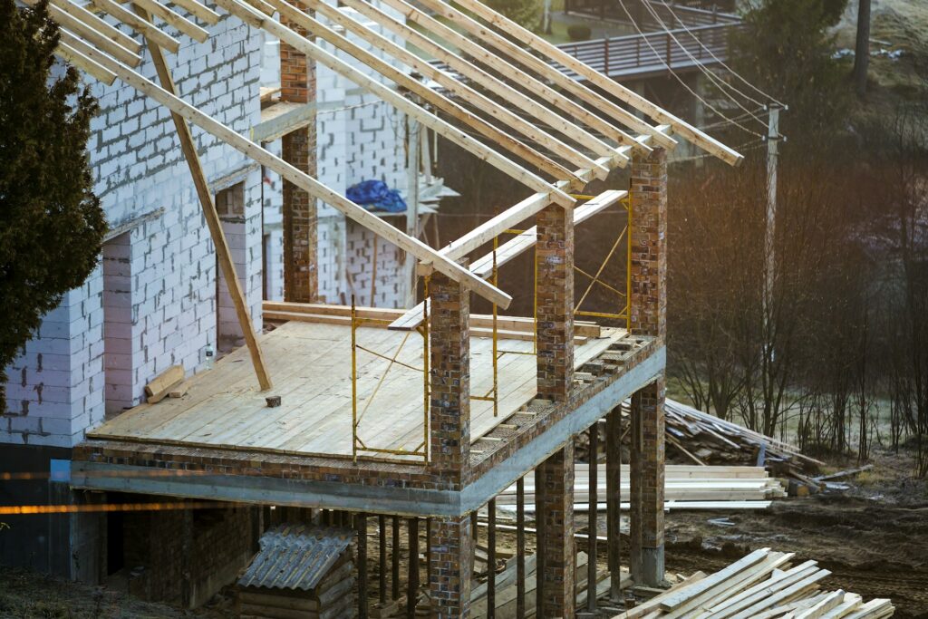 Cottage house building under construction with walls made of hollow foam insulation blocks, wooden